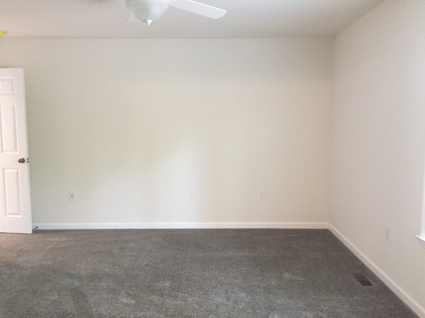 Empty room with white walls and a ceiling fan