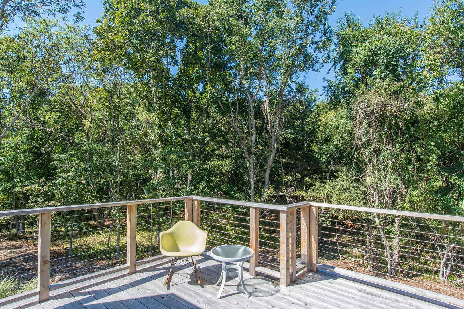 Wooden deck with chairs overlooking lush forest