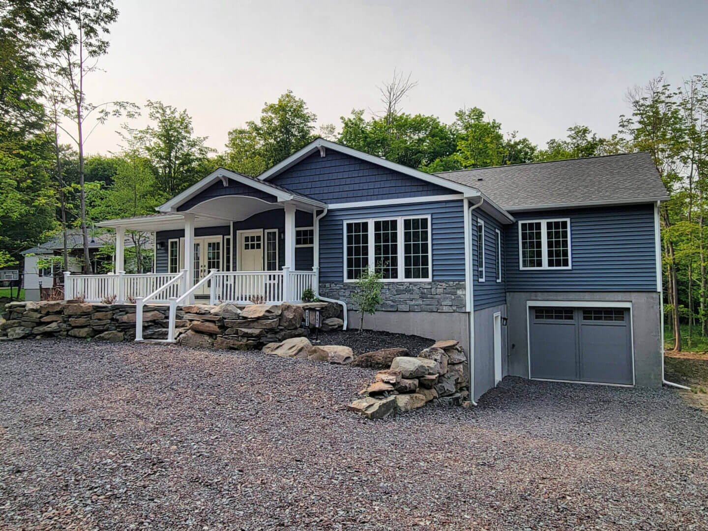 Blue ranch-style house with porch and garage