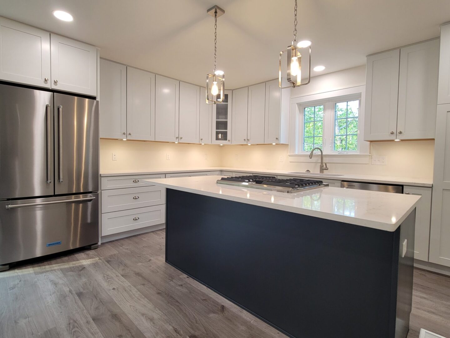 Modern kitchen with island and stainless appliances.