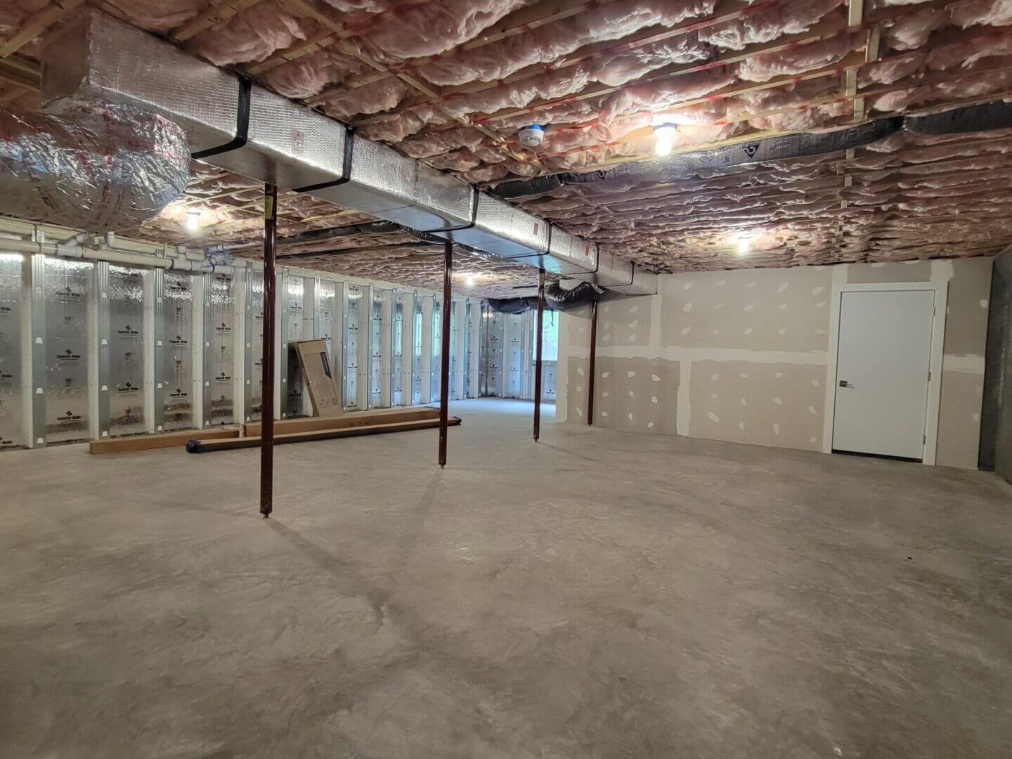 Unfinished basement with insulation and ductwork.