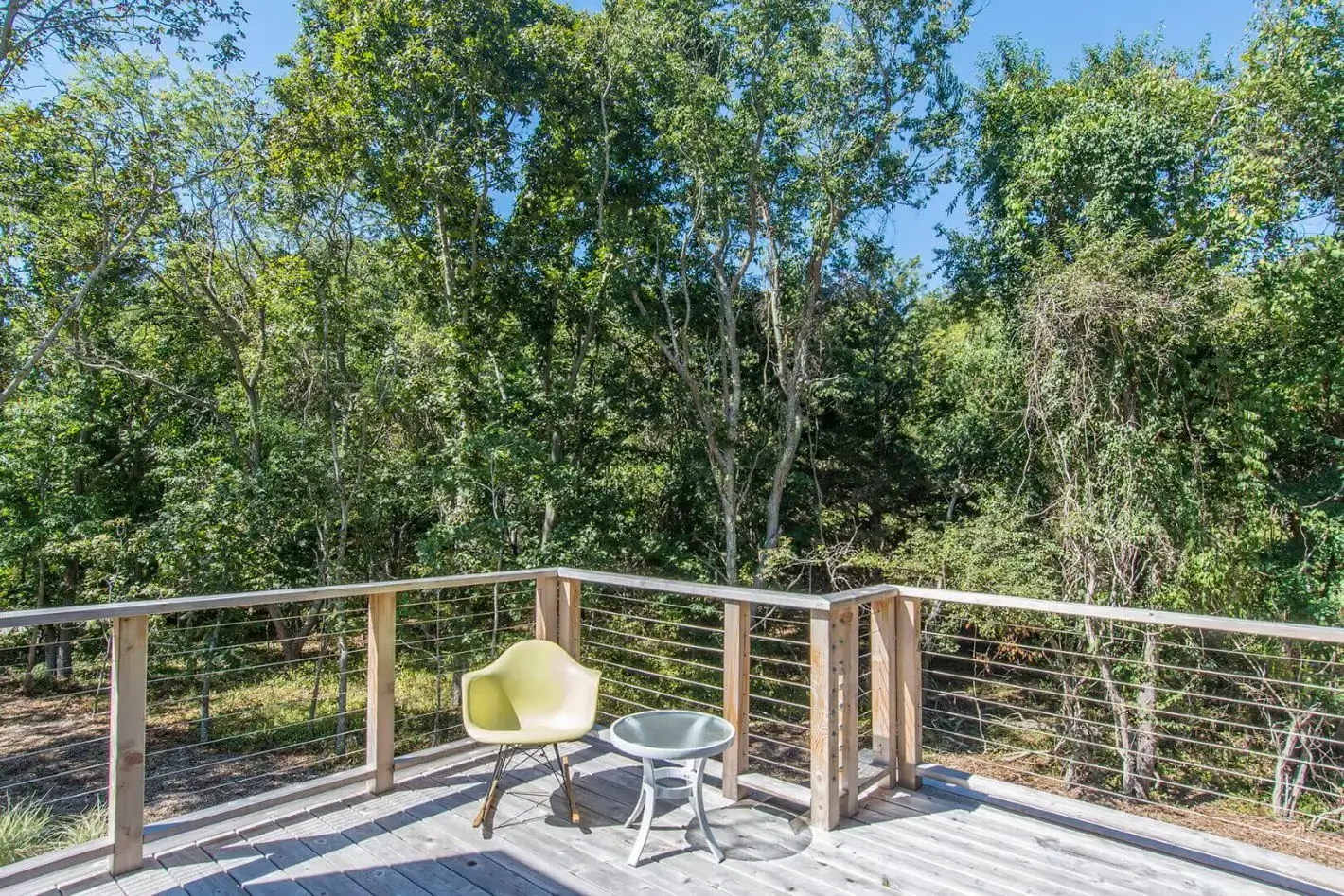 Sunlit deck with chairs overlooking woods